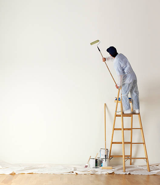 Professional painter painting an interior wall representing Fairway Painting and More, your Fayetteville painting experts
